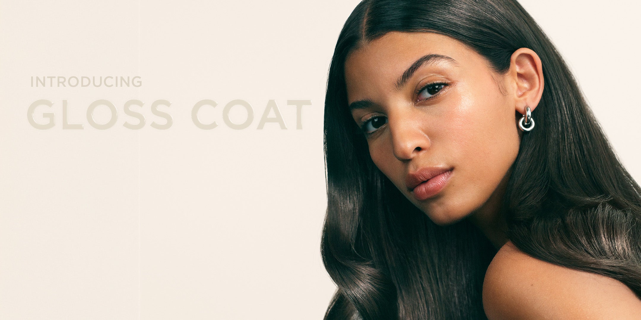 Modell med glansigt hår och text Introducing Gloss Coat
