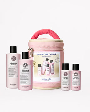 Maria Nila hair care products including bottles and a pink travel case on a white background