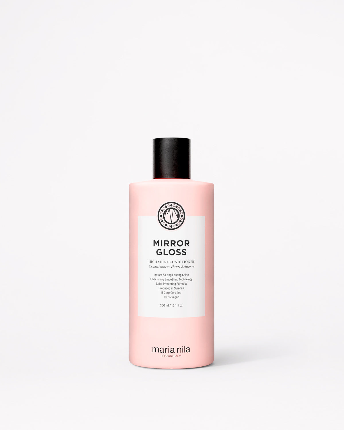 En flaska Maria Nila Mirror Gloss-balsam i en ljusrosa flaska med svart lock och en vit etikett, placerad mitt på en ljusgrå bakgrund.