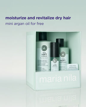 Maria Nila True Soft hårvårdsset i en ljust mintgrön box, med schampo, balsam och ett litet gratis mini Argan Oil-kort, med reklamtext ovanför på en ljus gradientbakgrund.