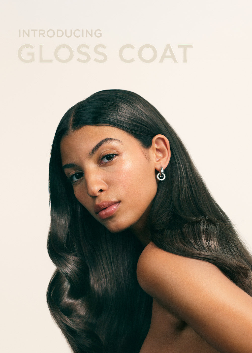 Modell med glansigt hår och text Introducing Gloss Coat