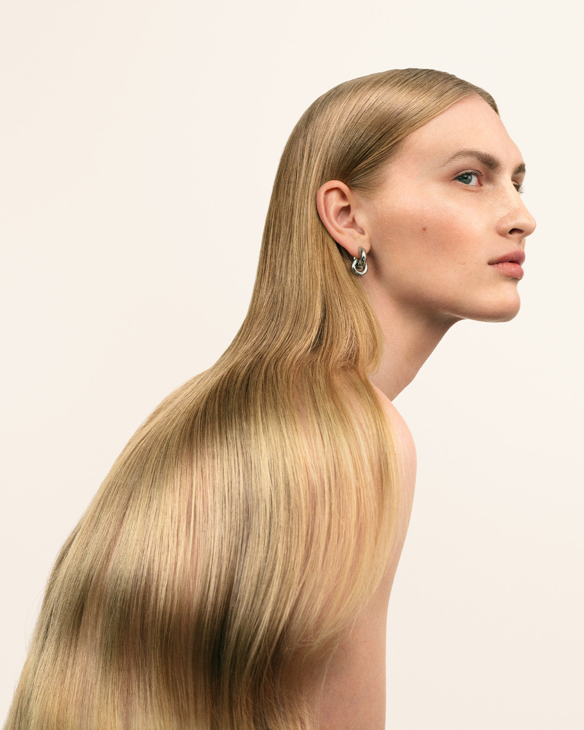 Modell med långt blont hår på vit bakgrund