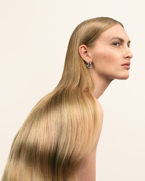 Modell med långt blont hår på vit bakgrund